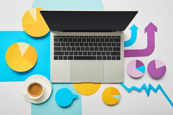 Top view of laptop with cup of coffee, paper charts and graph, pointers on white background — Stock Photo