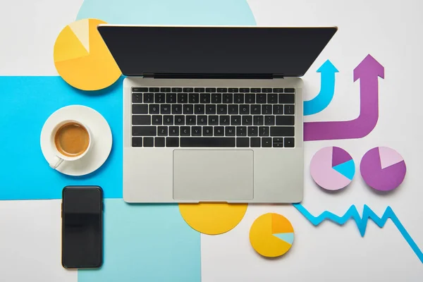 Vue du dessus de l'ordinateur portable ouvert avec tasse de café, graphiques et graphiques, pointeurs sur fond blanc — Photo de stock