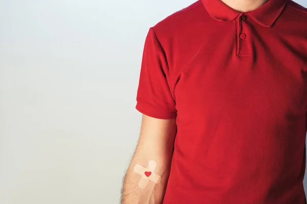 Cropped view of patient in red t-shirt with plasters — Stock Photo