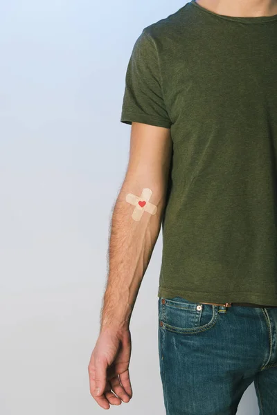 Vista cortada do paciente em camiseta verde e jeans azul com emplastros, conceito de doação de sangue — Fotografia de Stock