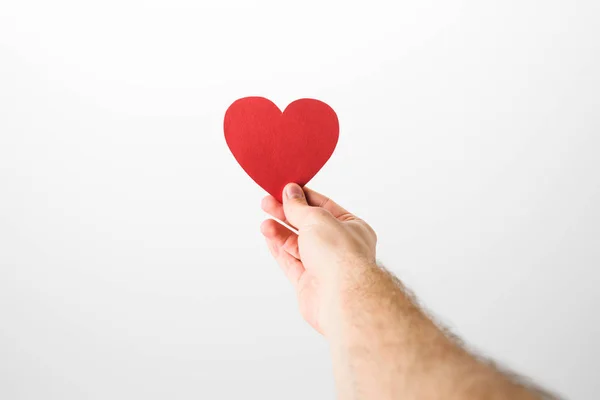 Vista recortada del hombre sosteniendo el corazón de papel sobre fondo gris — Stock Photo