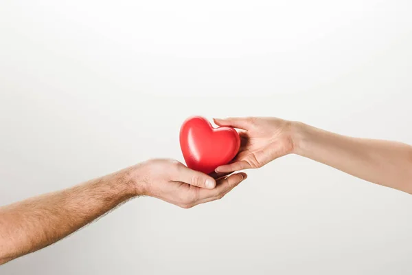 Cropped view of man and woman holding toy heart on grey background — Stock Photo