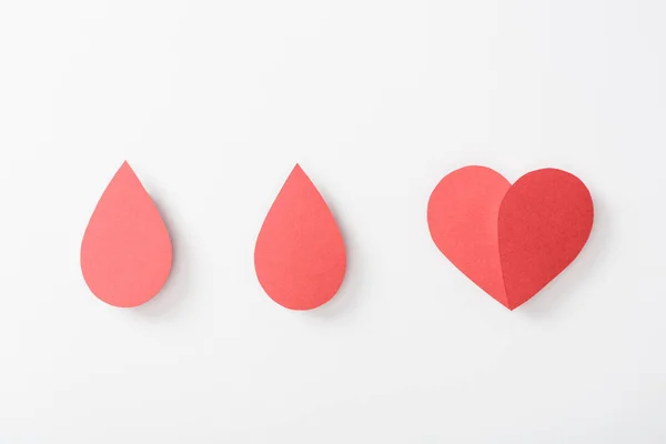 Top view of paper heart and drops on white background — Stock Photo