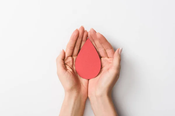 Partial view of woman holding paper drop on grey background — Stock Photo