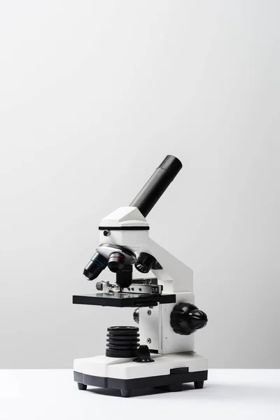 Microscope sur fond gris avec espace de copie — Photo de stock