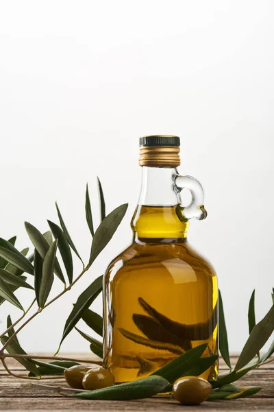 Oil tree branch and bottle of oil  isolated on grey — Stock Photo