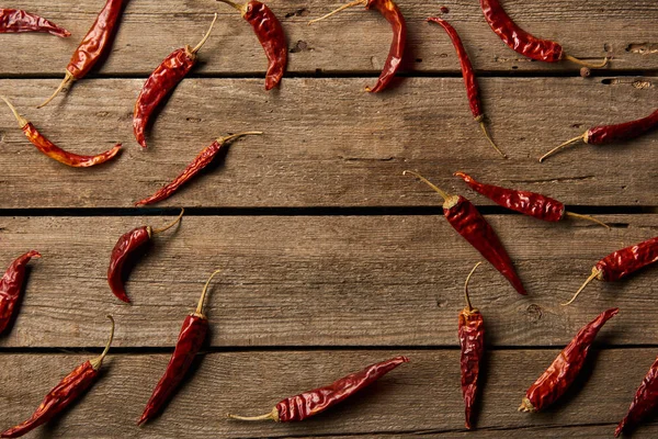 Vue de dessus des piments rouges sur fond en bois — Photo de stock