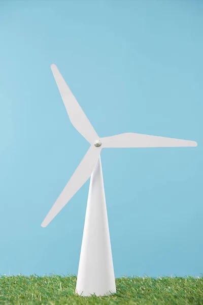 Modelo de moinho de vento branco na grama verde e fundo azul — Fotografia de Stock