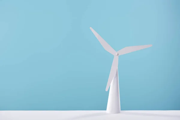 Modelo de moinho de vento branco no fundo azul e mesa — Fotografia de Stock