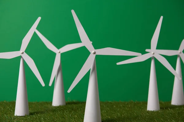 White windmill models on grass and green background — Stock Photo