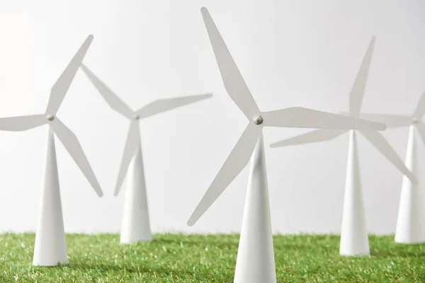 Modelos de molino de viento sobre hierba verde y fondo blanco - foto de stock