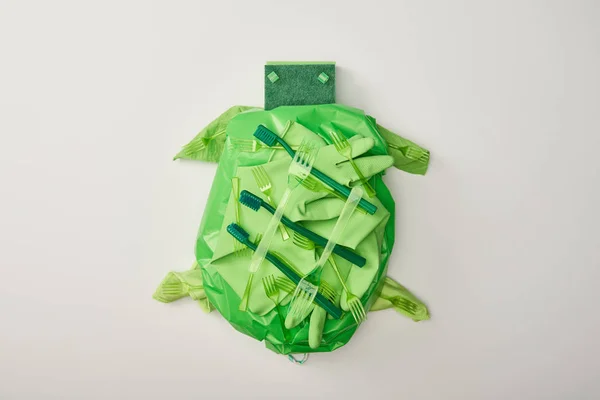 Top view of turtle figure made from disposable plastic tableware, bag, sponges and rubber gloves isolated on white — Stock Photo