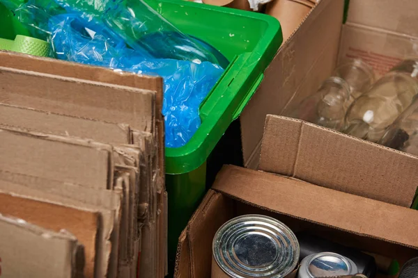 Sorted trash of cardboard, glass and plastic bottles, polyethylene, iron cans — Stock Photo