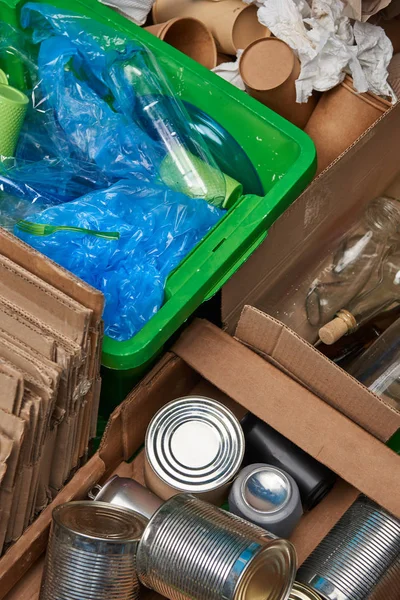 Sorted trash of cardboard, glass and plastic bottles, polyethylene, cups, iron cans — Stock Photo