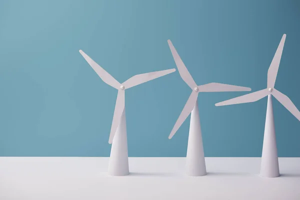 Modelos de molino de viento sobre mesa blanca y fondo azul — Stock Photo