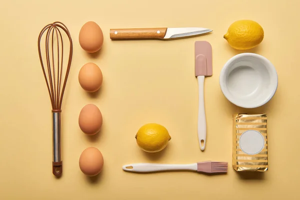Tendido plano con utensilios de cocina e ingredientes crudos sobre fondo amarillo - foto de stock