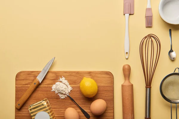 Flat lay with cooking utensils and ingredients on wooden chopping board — Stock Photo