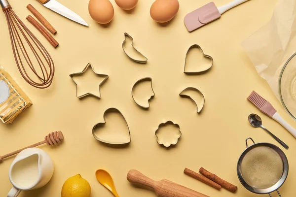 Top view of bakery ingredients and cooking utensils around dough molds — Stock Photo