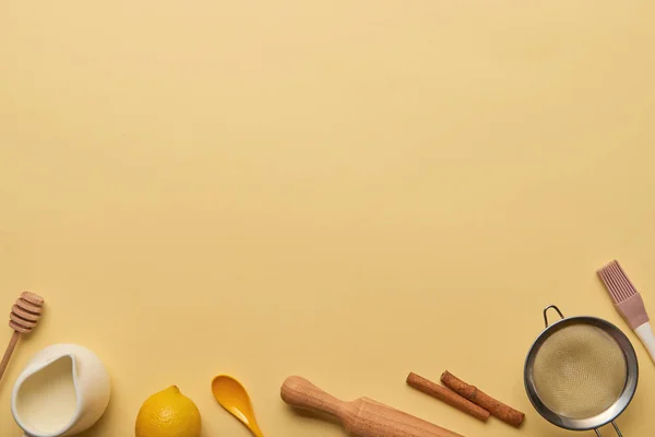 Vue de dessus des ingrédients de boulangerie et des ustensiles de cuisine sur fond jaune avec espace de copie — Photo de stock