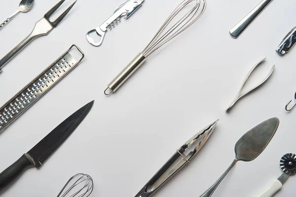 Flache Liege mit metallenen Kochutensilien auf grauem Hintergrund — Stockfoto