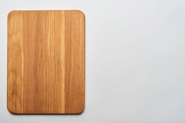 Top view of empty wooden chopping board on grey background — Stock Photo