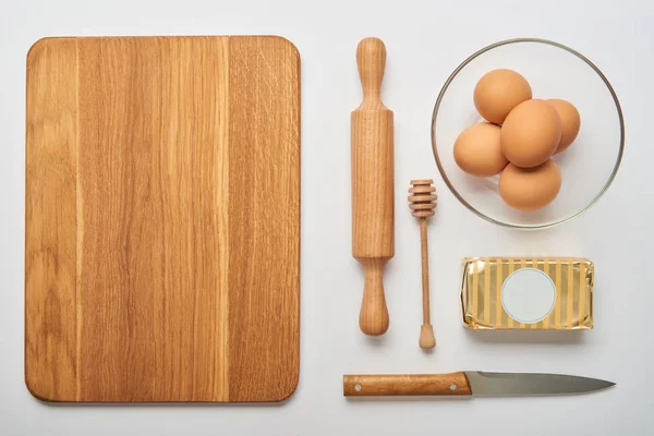 Плоский ліжко з дерев'яним посудом для приготування їжі та хлібобулочними інгредієнтами на сірому фоні — стокове фото