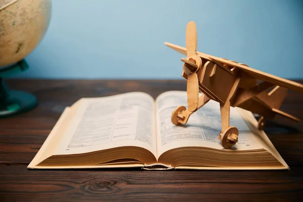 Foco seletivo de livro e avião de brinquedo na mesa — Fotografia de Stock