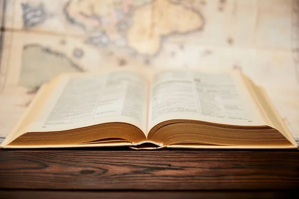 Focus sélectif du livre et carte sur table en bois — Photo de stock