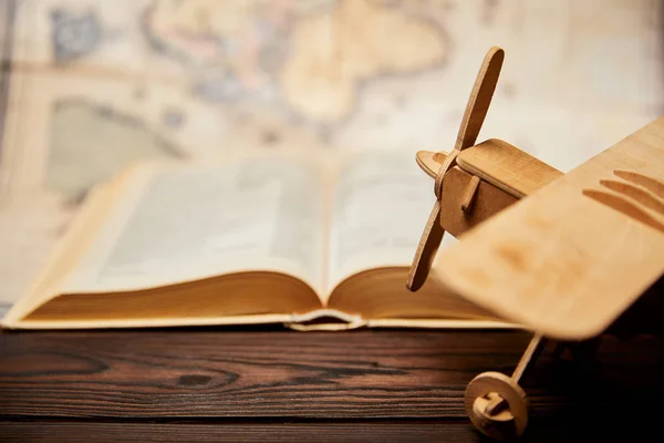 Concentration sélective de jouet avion, livre et carte sur table en bois — Photo de stock