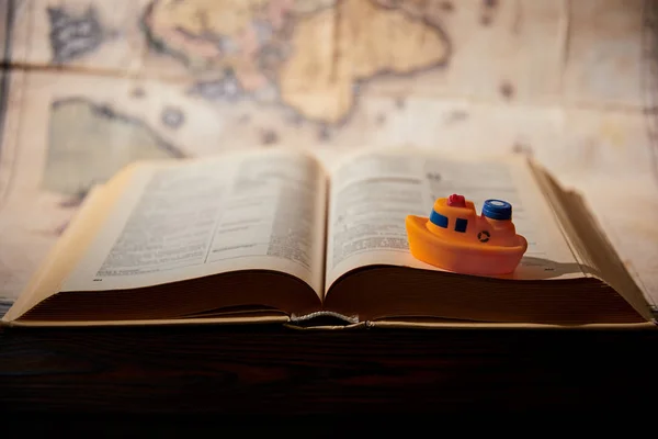 Foco seletivo de navio de brinquedo, livro e mapa na mesa — Fotografia de Stock
