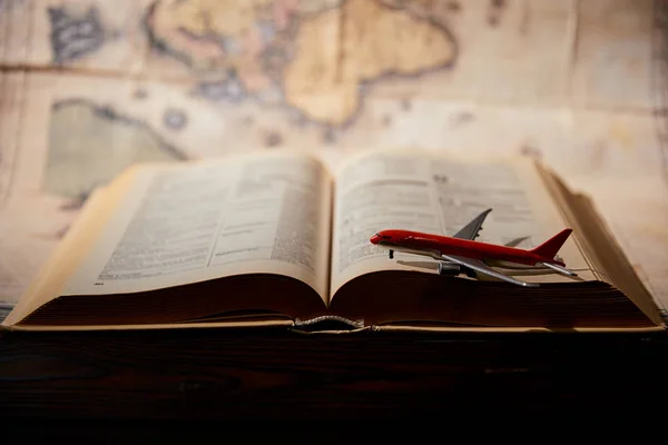 Foco seletivo de avião de brinquedo, livro e mapa na mesa — Fotografia de Stock