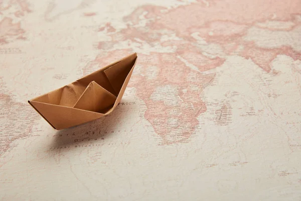 Barco de papel en el mapa del mundo vintage - foto de stock
