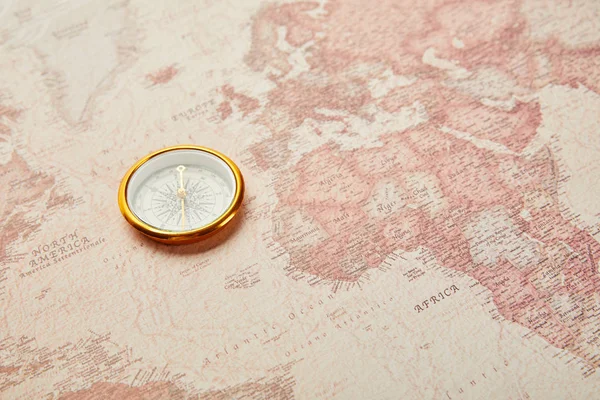 Brújula dorada en el mapa del mundo vintage - foto de stock