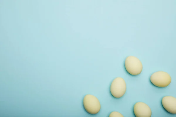 Vue du dessus des œufs de Pâques peints sur fond bleu — Photo de stock