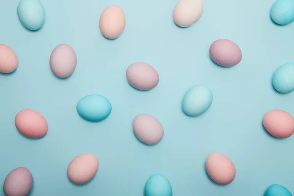 Vista superior de los huevos de Pascua sobre fondo azul - foto de stock