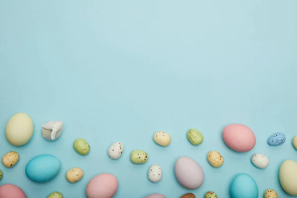 Top view of toy bunny, easter chicken and quail eggs on blue background with cope space — Stock Photo