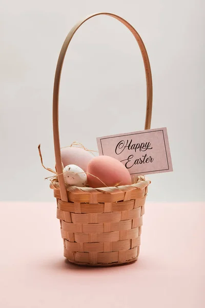 Painted easter chicken and quail egg in straw basket, card with happy easter lettering — Stock Photo