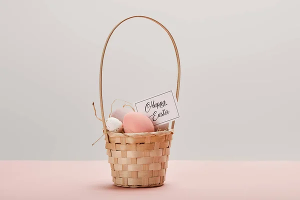 Пасхальное куриное и перепелиное яйцо в соломенной корзине, открытка со счастливой пасхальной надписью — стоковое фото