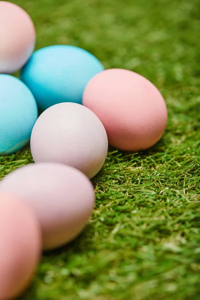 Enfoque selectivo de huevos de Pascua pintados en la hierba - foto de stock