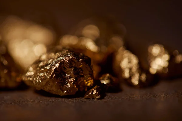Selektive Fokussierung von goldenen Steinen auf verschwommenem Hintergrund — Stockfoto