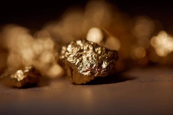 Вибірковий фокус золотих каменів на мармуровому і темному розмитому фоні — стокове фото