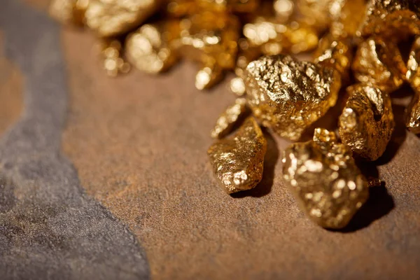 Selective focus of golden stones on brown marble background — Stock Photo