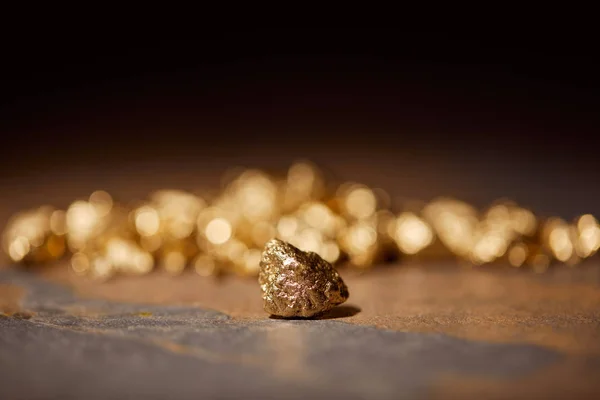 Selective focus of golden stones on brown marble and blurred background — Stock Photo