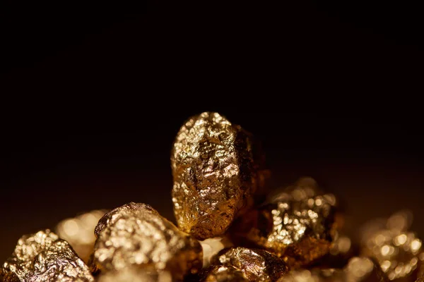 Selective focus of golden stone isolated on black — Stock Photo