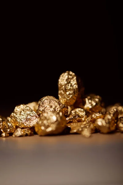 Золотые камни на сером фоне, изолированные на черном — стоковое фото