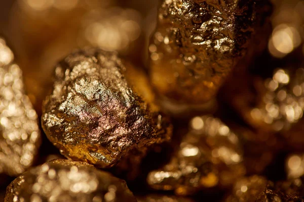 Enfoque selectivo de piedras doradas con luces brillantes - foto de stock