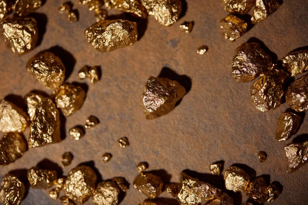 Draufsicht auf goldene Steine auf braunem und grauem Marmorhintergrund — Stockfoto