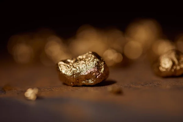 Селективный фокус золотого камня на коричневом и сером мраморе размытый фон — стоковое фото