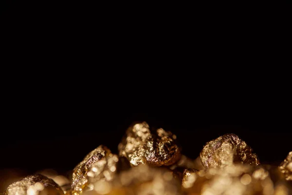 Foco seletivo de pedras de ouro isoladas em preto — Fotografia de Stock