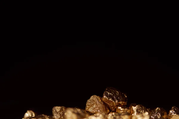 Piedras doradas con el primer plano borroso aislado en negro - foto de stock